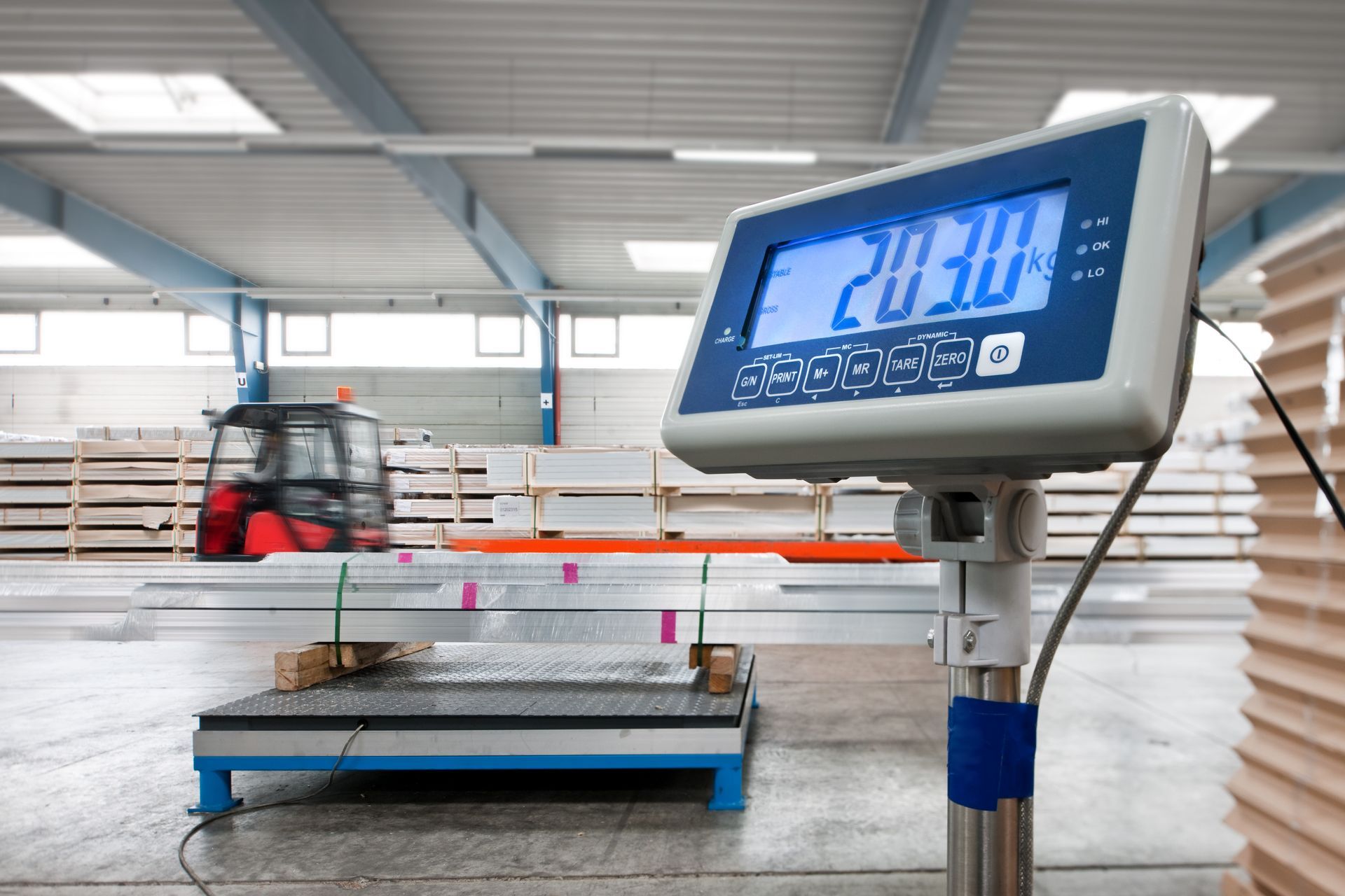 Digital commercial scale weighing materials in warehouse.