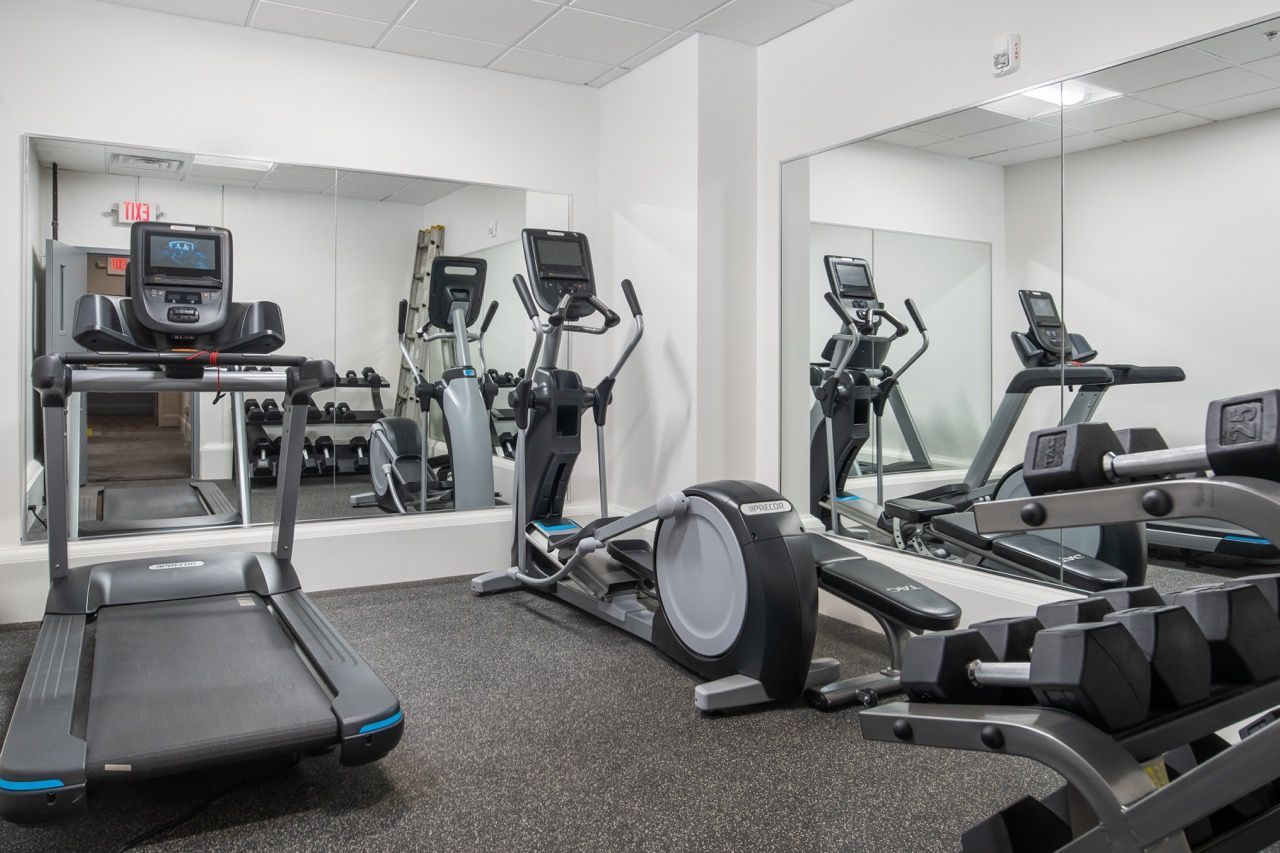 Fitness center with treadmills, elliptical machines, and free weights.