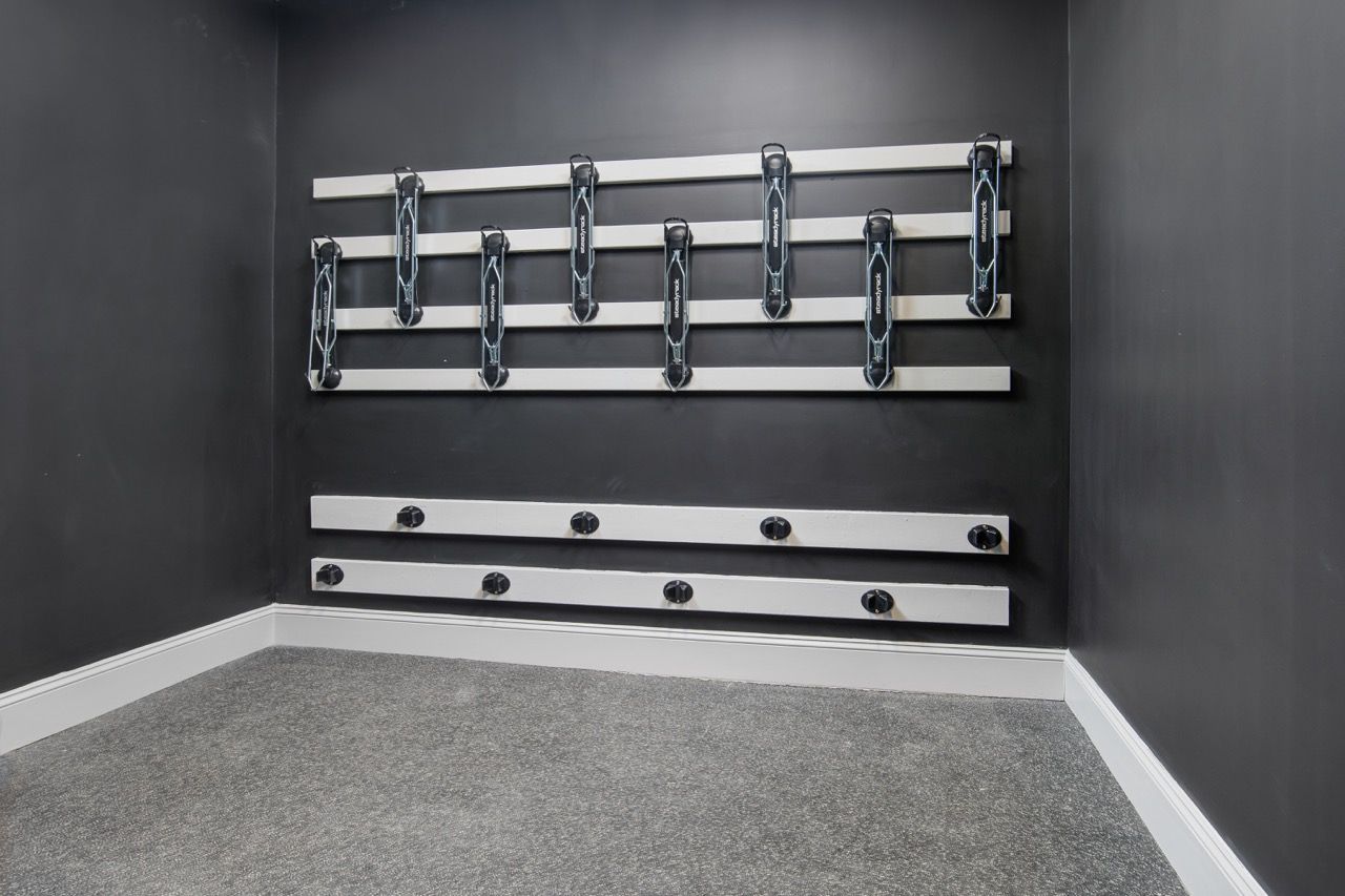 Corner of a small gym with a wall-mounted rack holding resistance bands.
