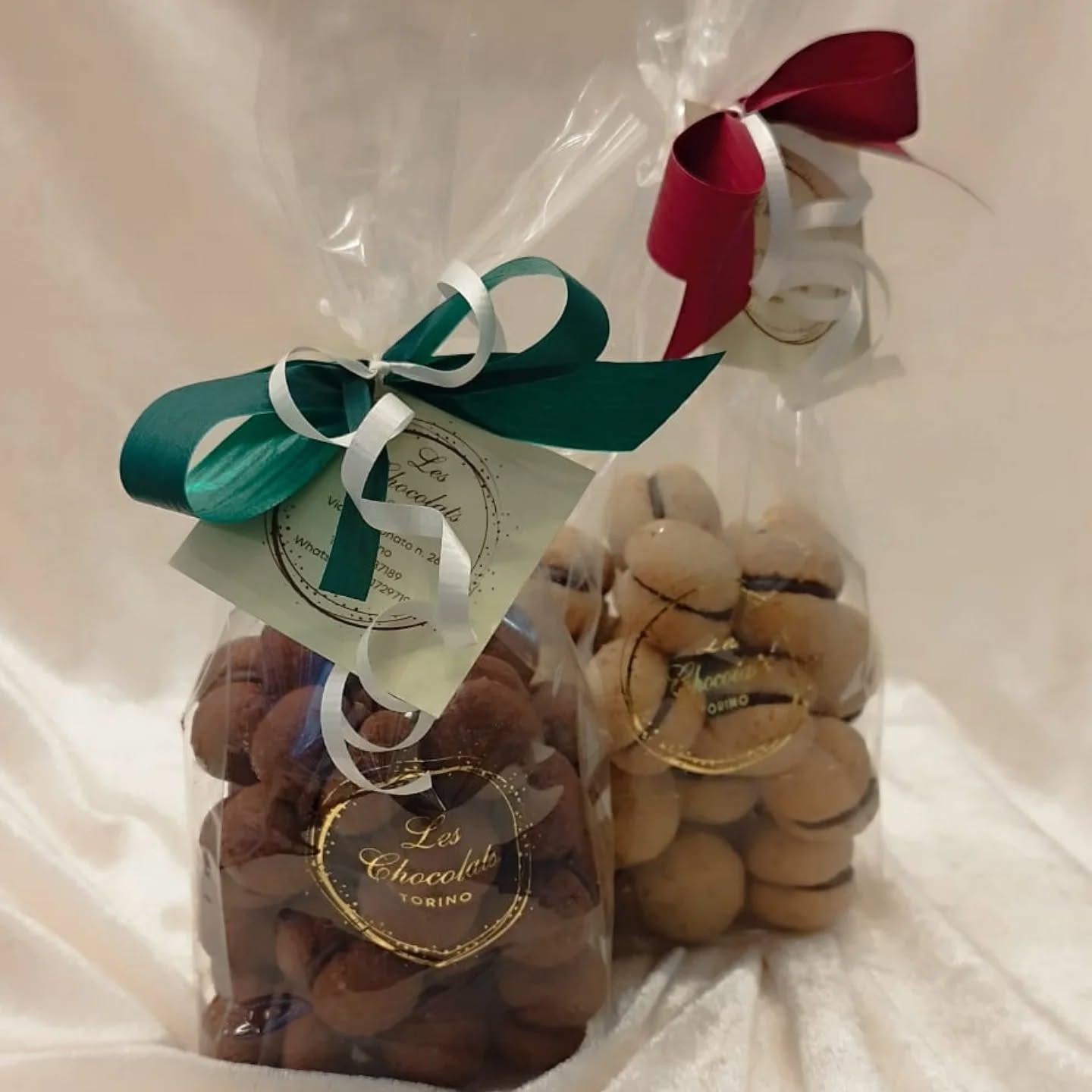 Due sacchetti di biscotti, uno al cioccolato e uno alla vaniglia, legati con nastri ed etichette.