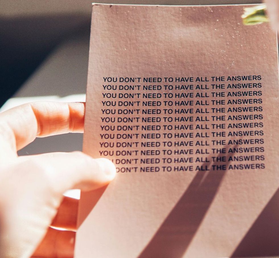 A hand holding a pink card repeated with the words,