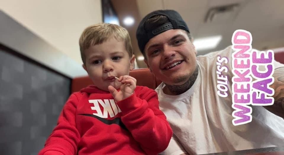 A man and a little boy are sitting at a table in a restaurant.