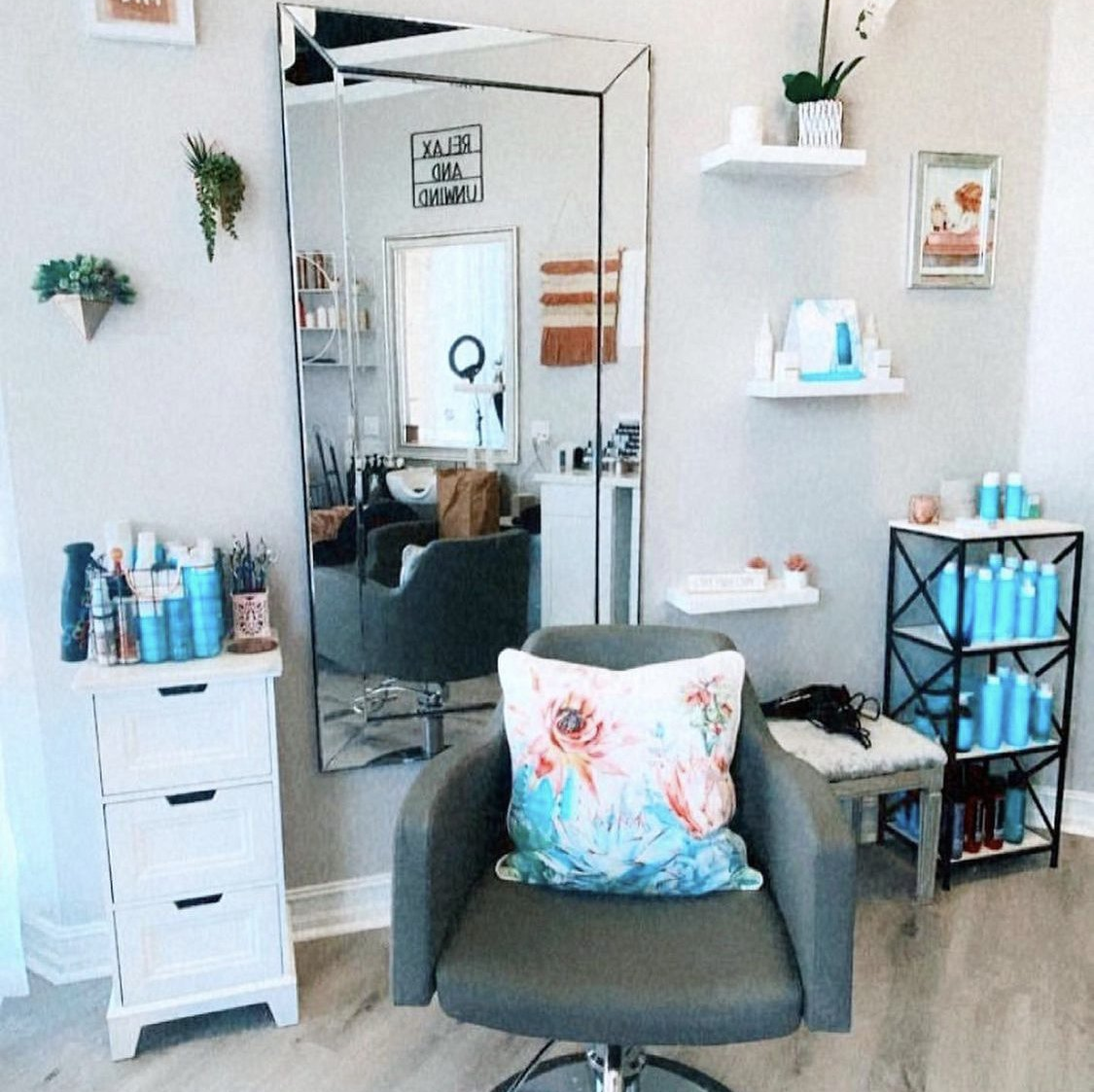 A chair in a salon with a floral pillow on it
