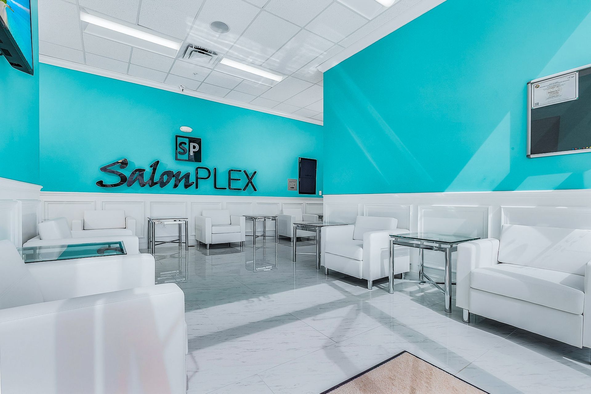 The interior of a salon plex with blue walls and white furniture