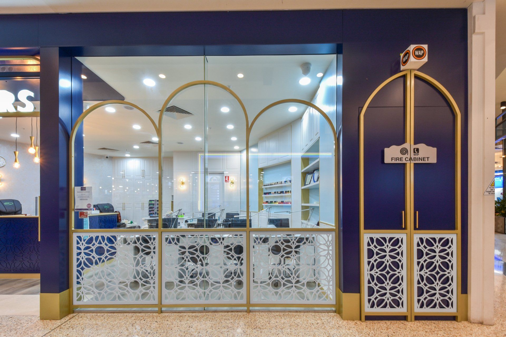 Blue and gold storefront with arched windows and decorative panels.