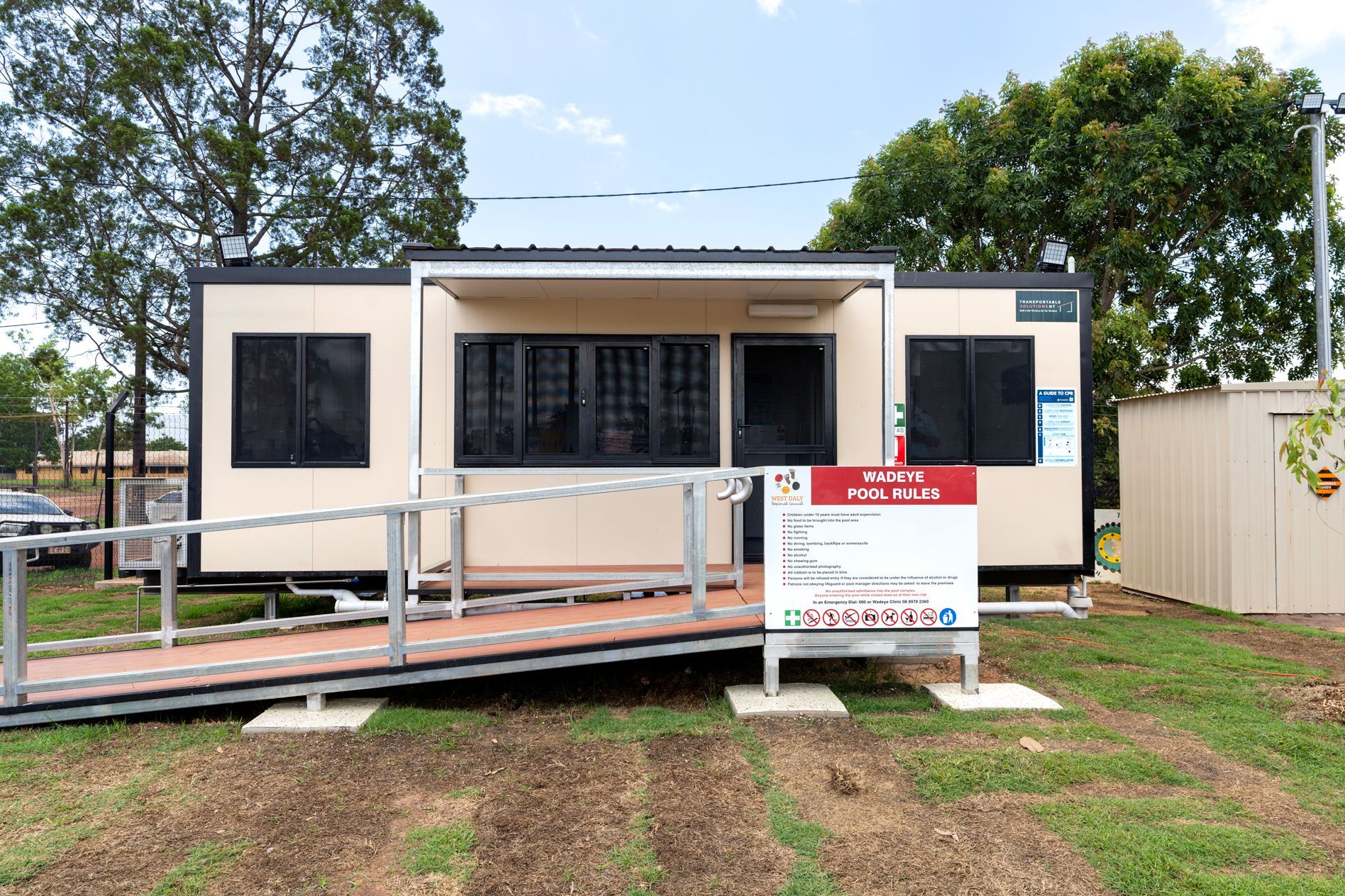 A beige modular building with a ramp, labeled