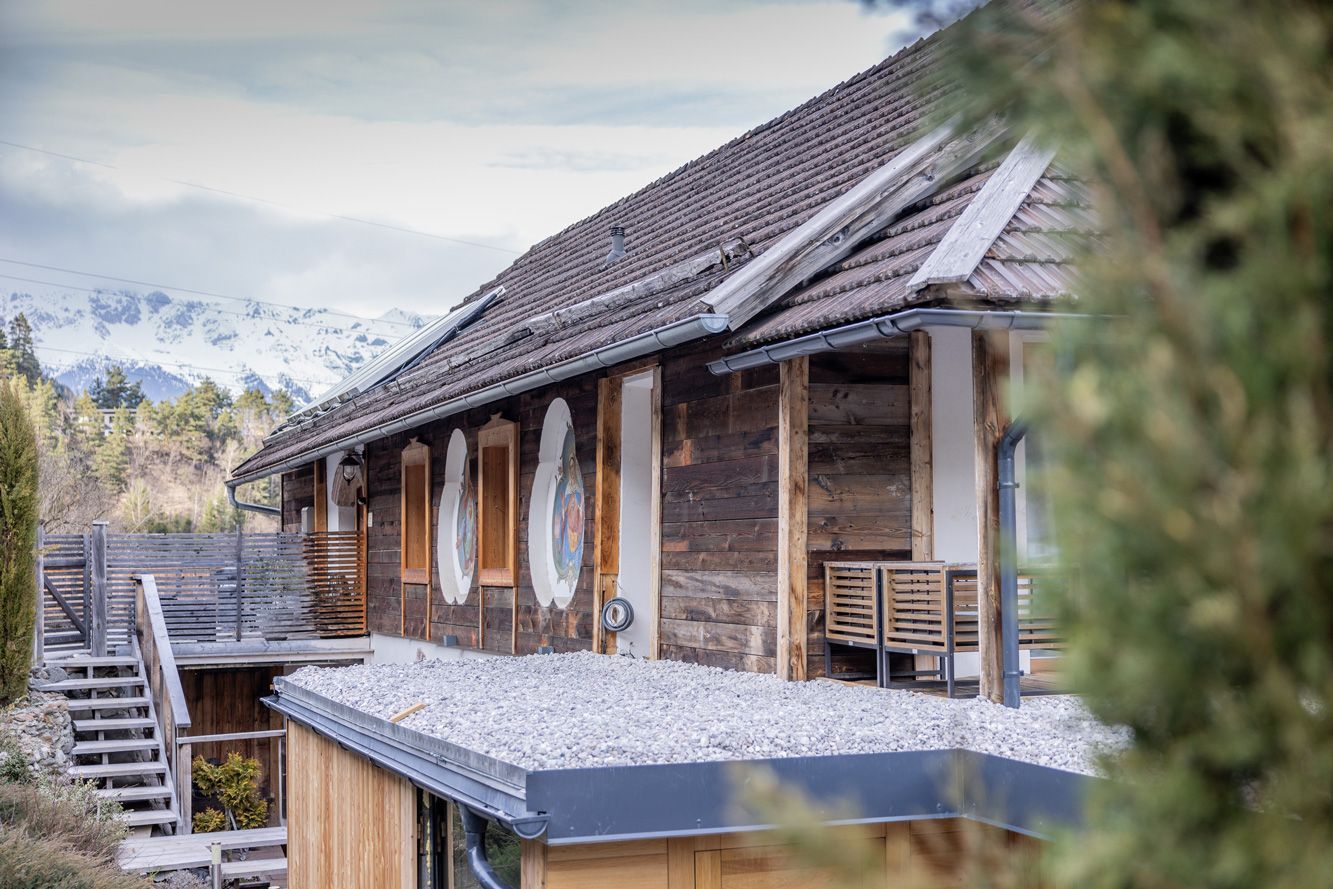 Rustic wooden house with sloped roof and mountain view in the background