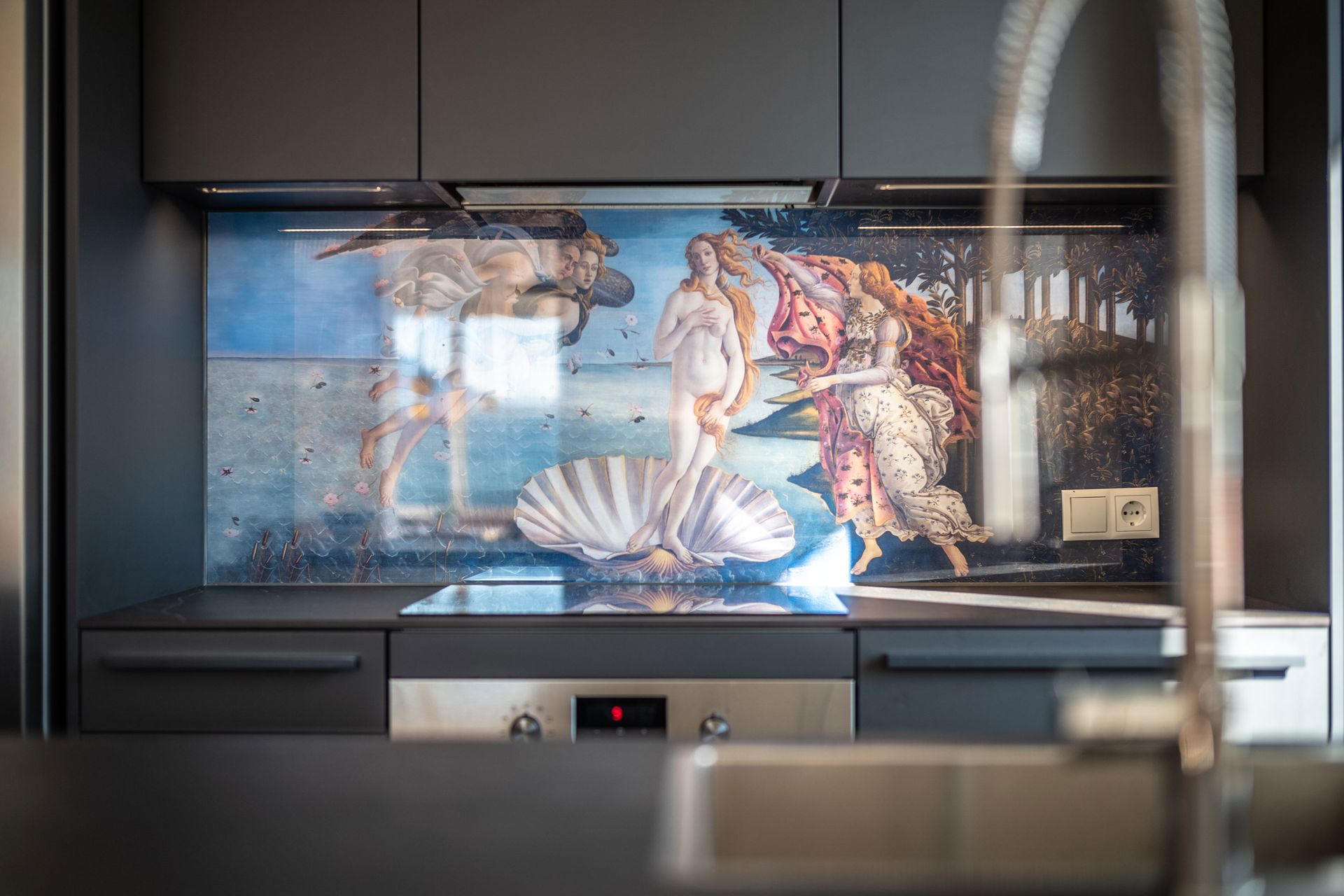 Aquarium-style mural with seashell and mermaid scene above a stainless steel sink and counter