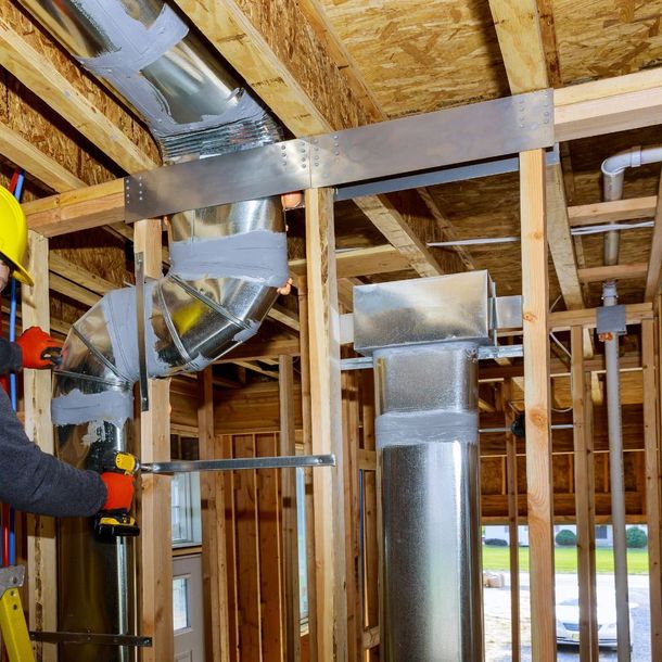 a man in a yellow hard hat is working on a metal pipe