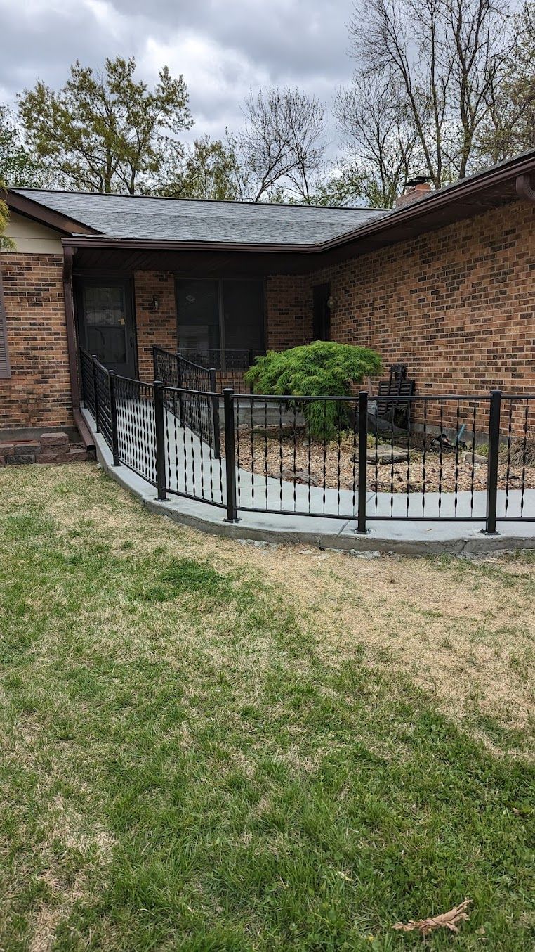 A brick house with a ramp and a fence in front of it.