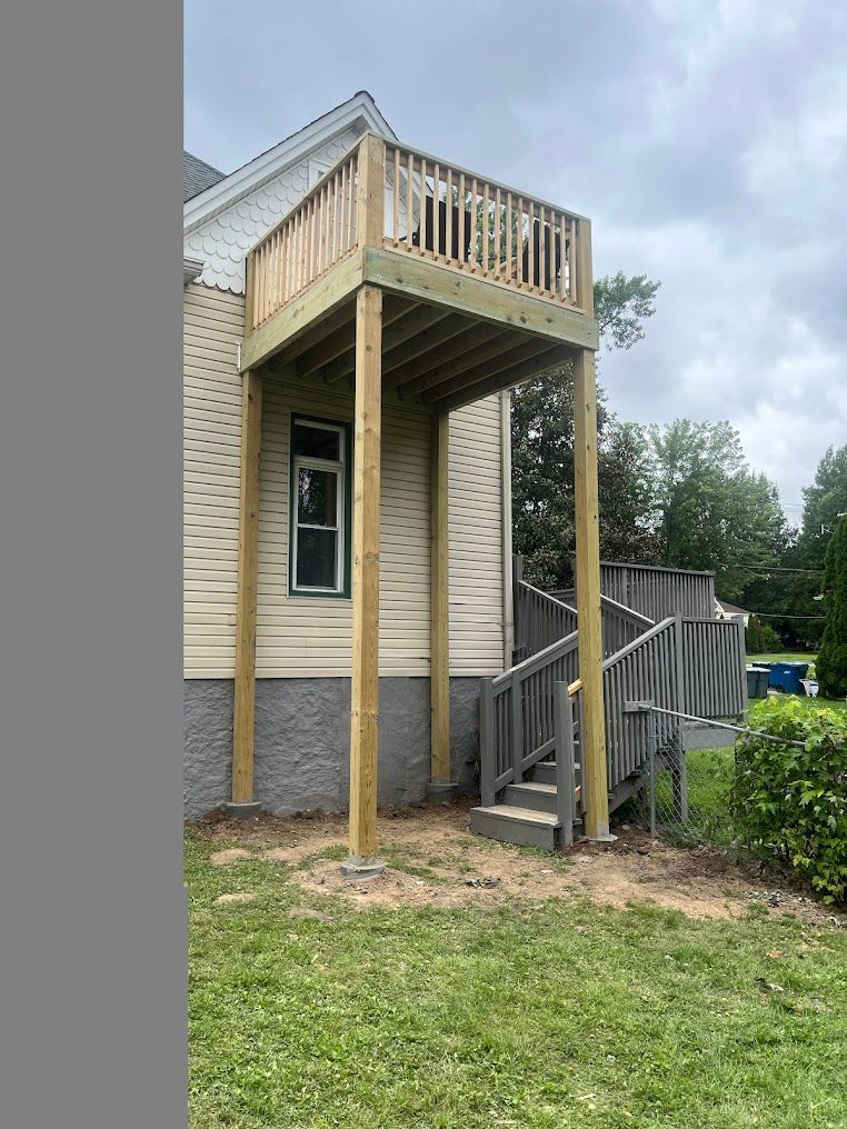 A wooden deck is being built on the side of a house.