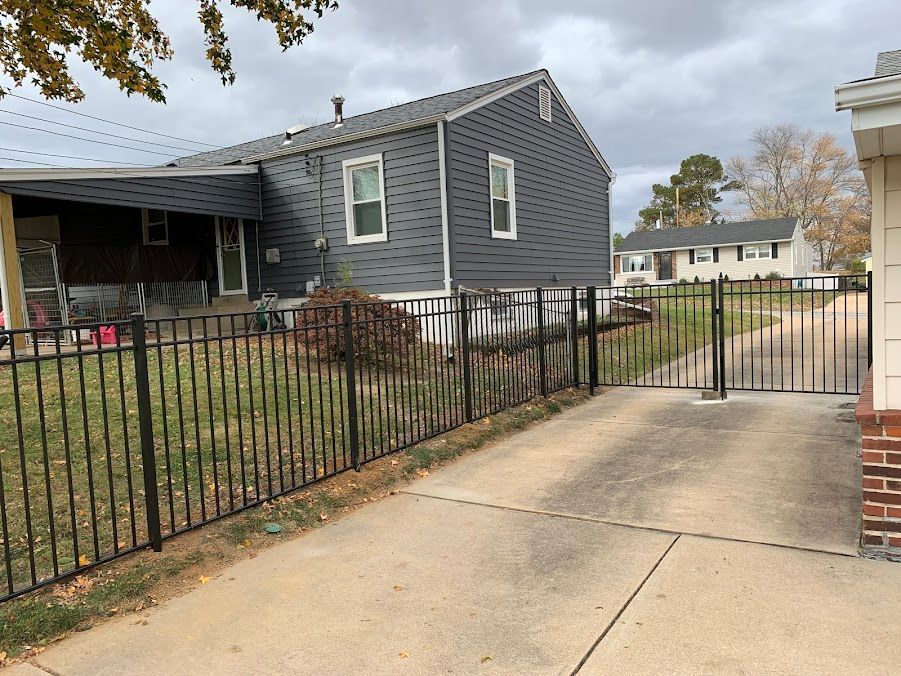 A house with a fence around it and a driveway leading to it.