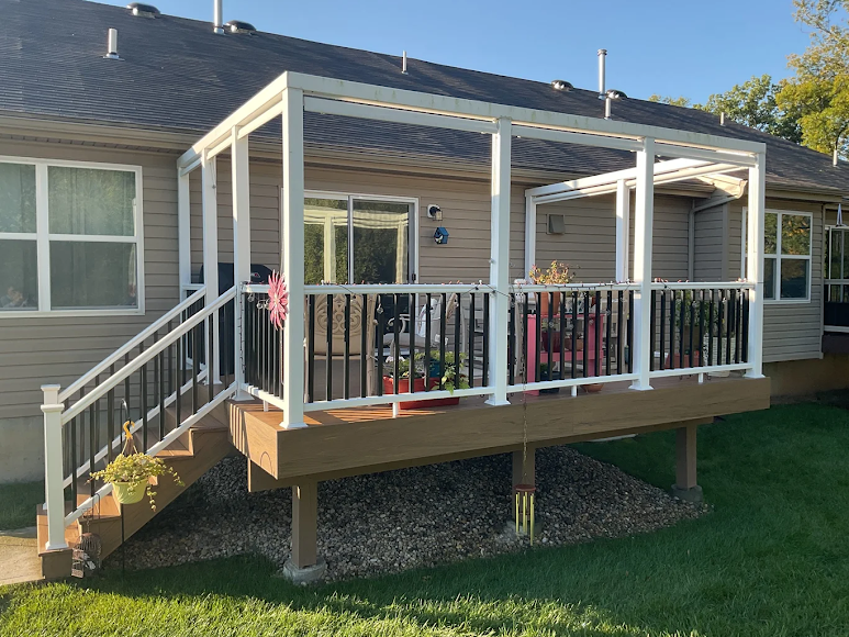 A house with a deck and stairs in front of it.