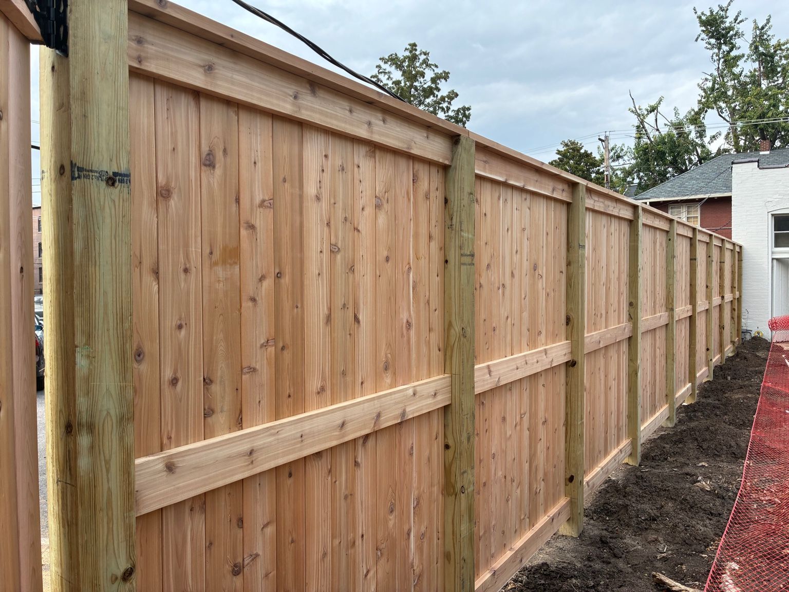 Wooden privacy fence with vertical boards and horizontal rails.