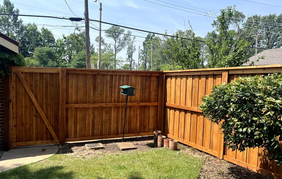 A white fence is sitting next to a house.