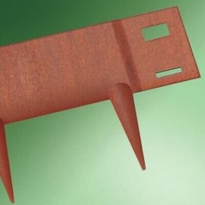 Three rusty metal garden tools or tines laid on green grass with a small hand tool nearby