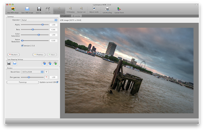 A computer screen shows  the Luminance HDR interface, To the right of a menu containing several adjustable sliders, there is a picture of a body of water with a city skyline in the distance. It is on a weird slanted angle. In the water a wooden platform juts out above the waves.