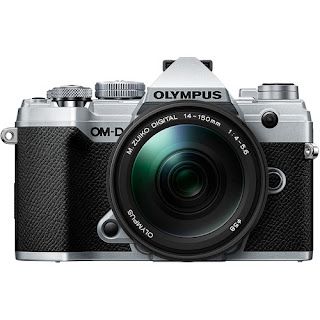 The olympus / om system om d e m5 mark ii is a camera with a large lens sitting on a white background.