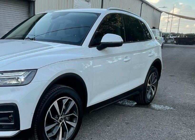 White Audi Q5 SUV parked outdoors, showcasing side profile with black accents and alloy wheels.