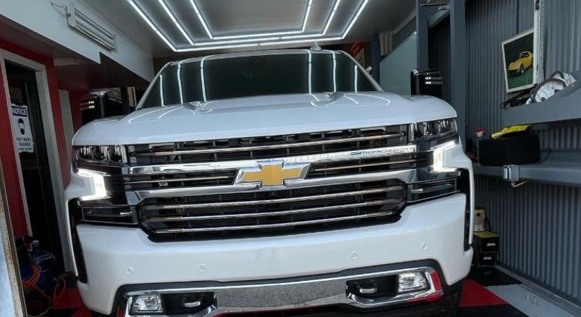 White Chevrolet SUV parked inside a well-lit garage.