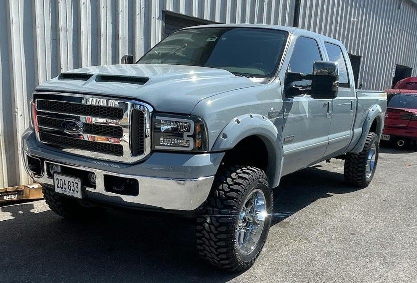 Gray Ford pickup truck with chrome accents and large tires parked outside.