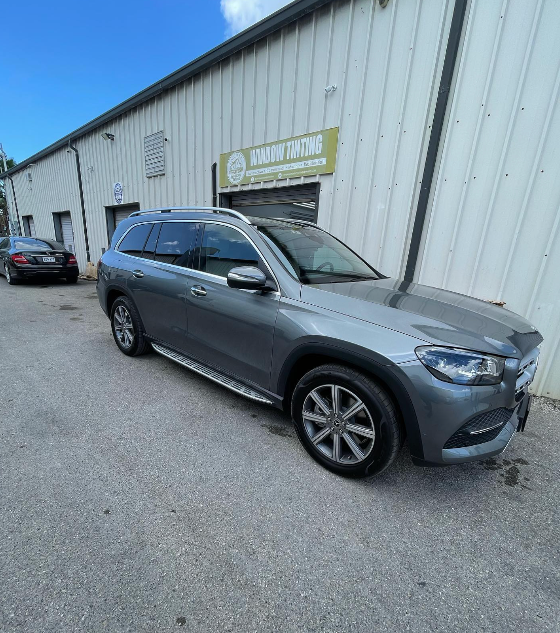 Gray SUV showcasing a glossy ceramic-coated finish in front of an auto detailing shop.