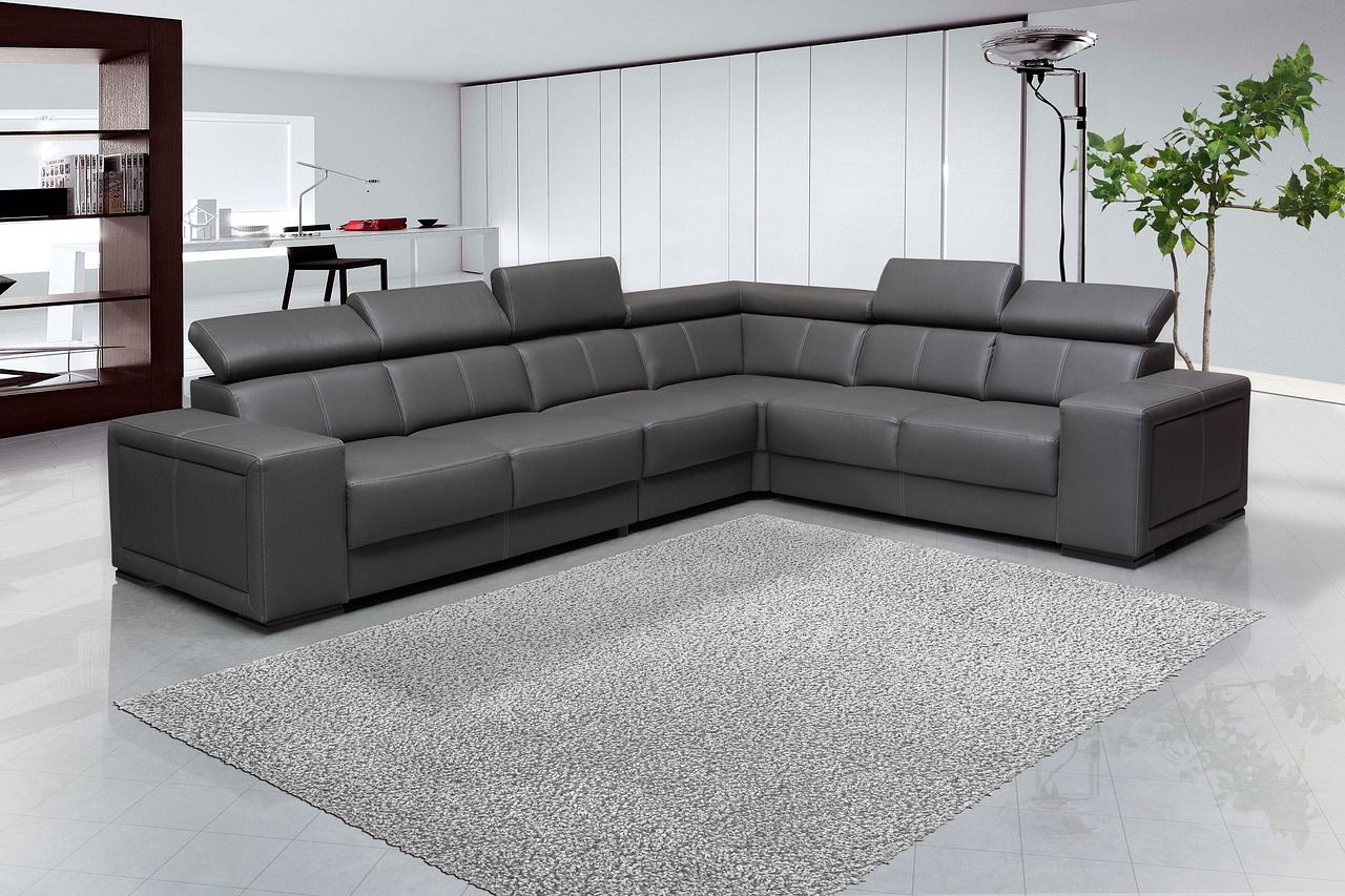 Gray leather sectional sofa on a gray rug in a modern living room.