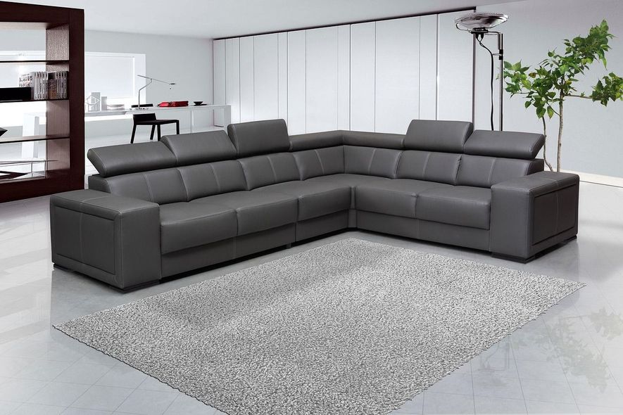 Gray leather sectional sofa on a gray rug in a modern living room.