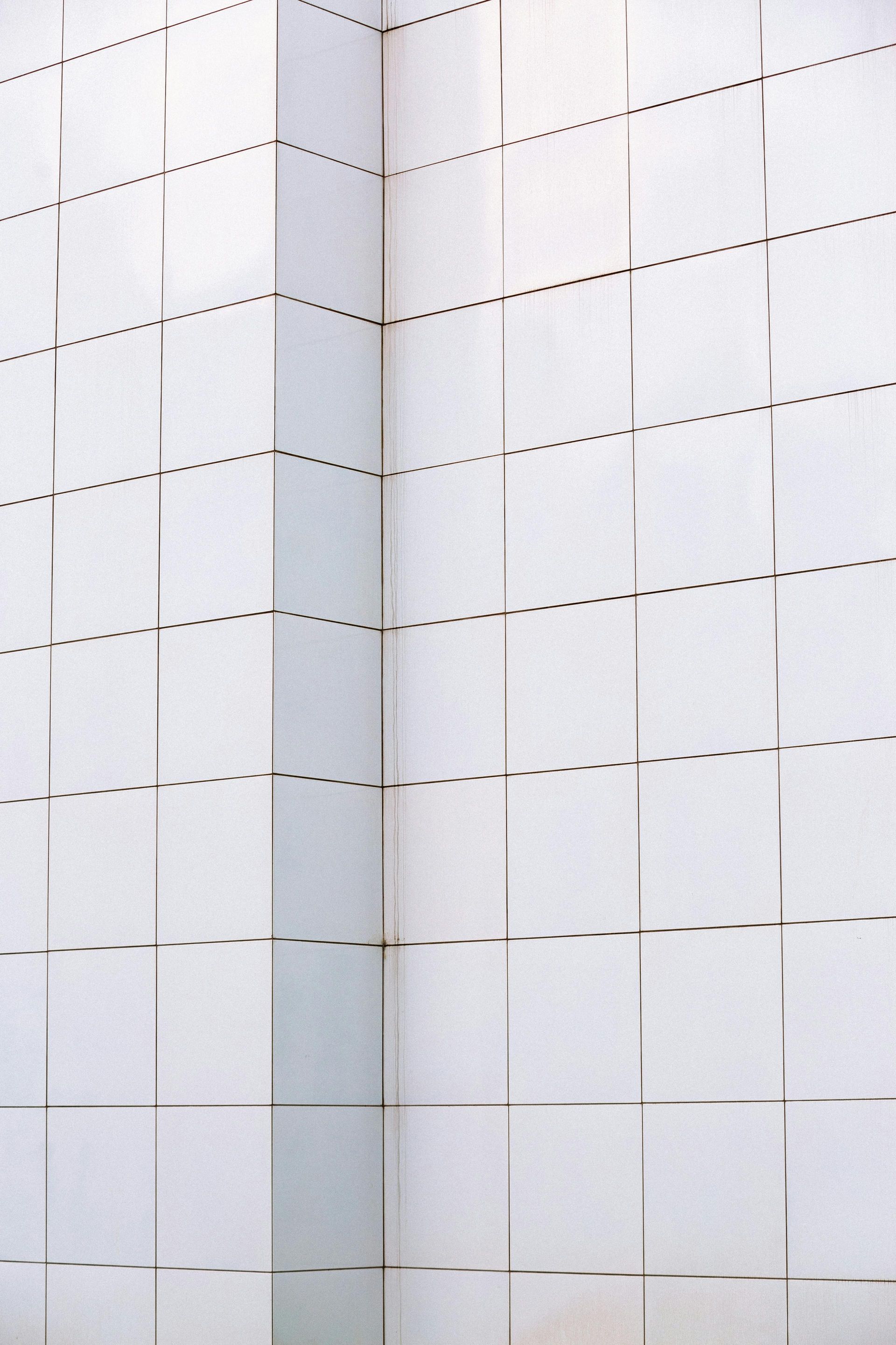 White building corner with dotted lines and vertical lines forming a grid pattern.