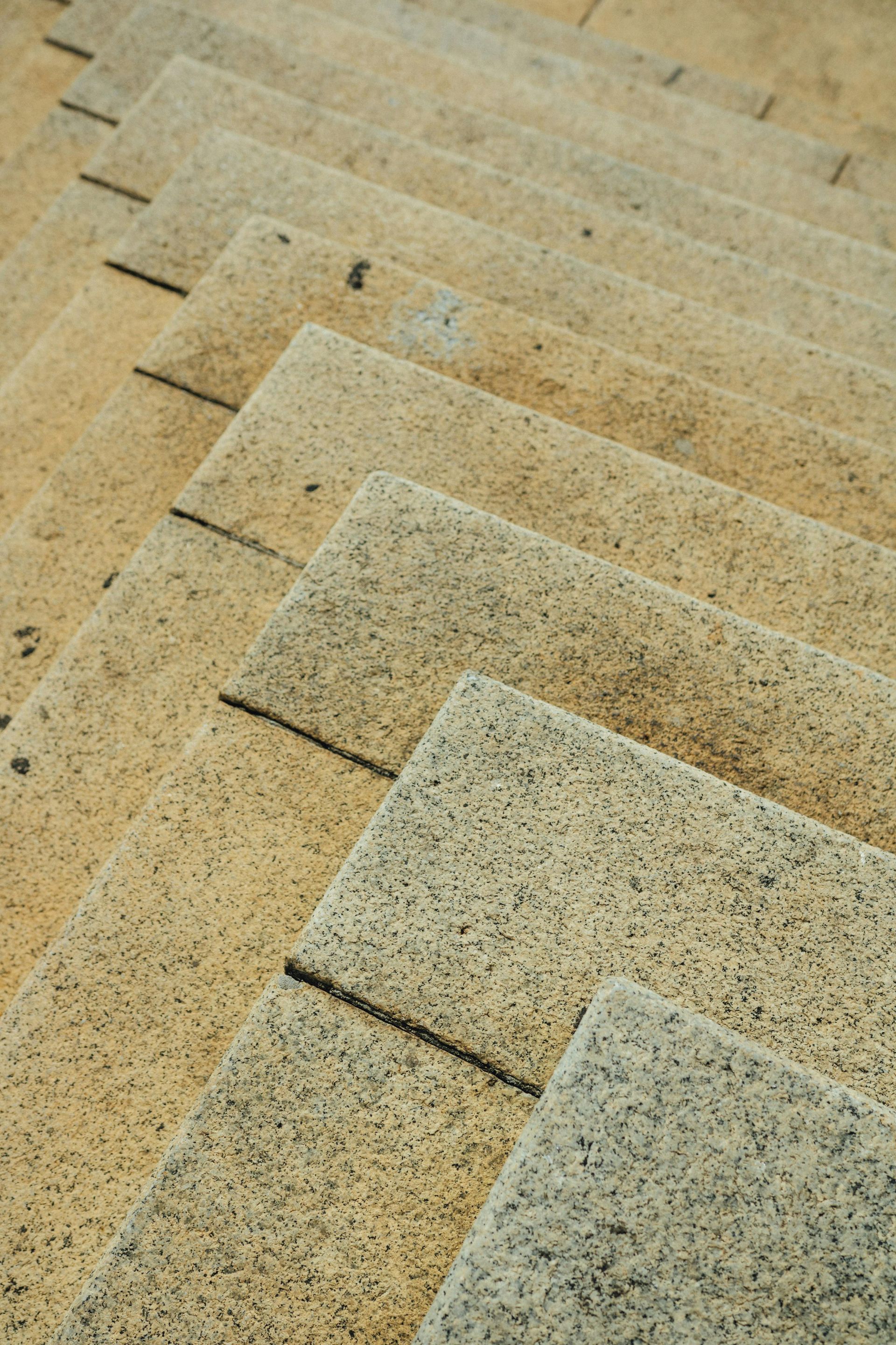 Stone steps, a light yellow-brown color, receding in a zig-zag pattern, shot from a high angle.