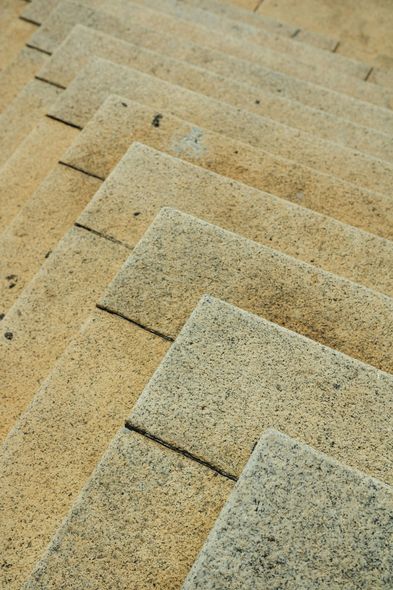 Stone steps, a light yellow-brown color, receding in a zig-zag pattern, shot from a high angle.