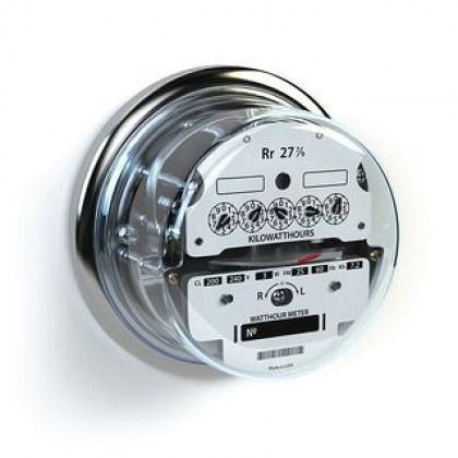 Electricity meter with a clear plastic cover and white dial mounted on a wall
