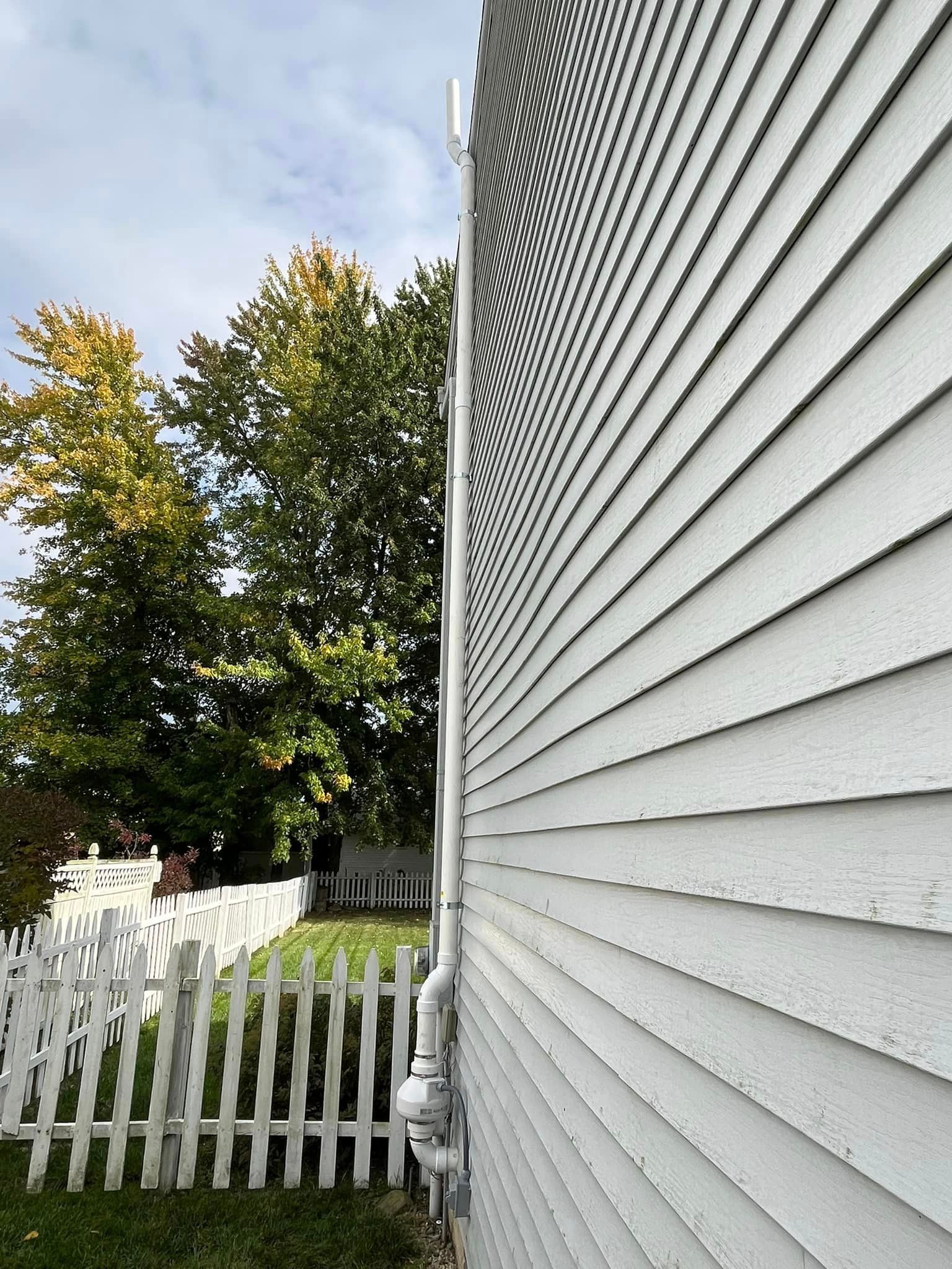 A white house with a white picket fence in front of it.