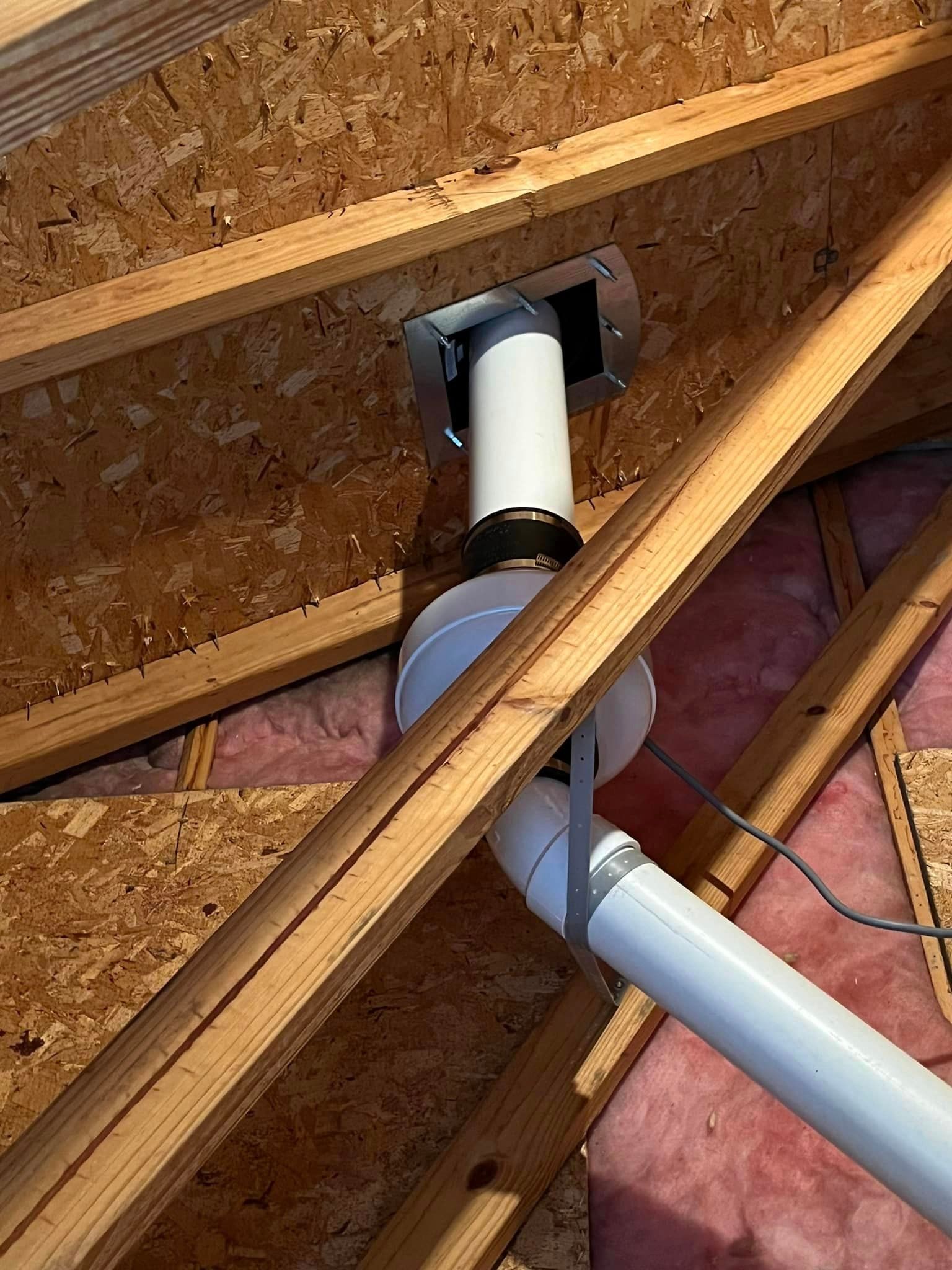 A white pipe is hanging from the ceiling of a wooden structure.
