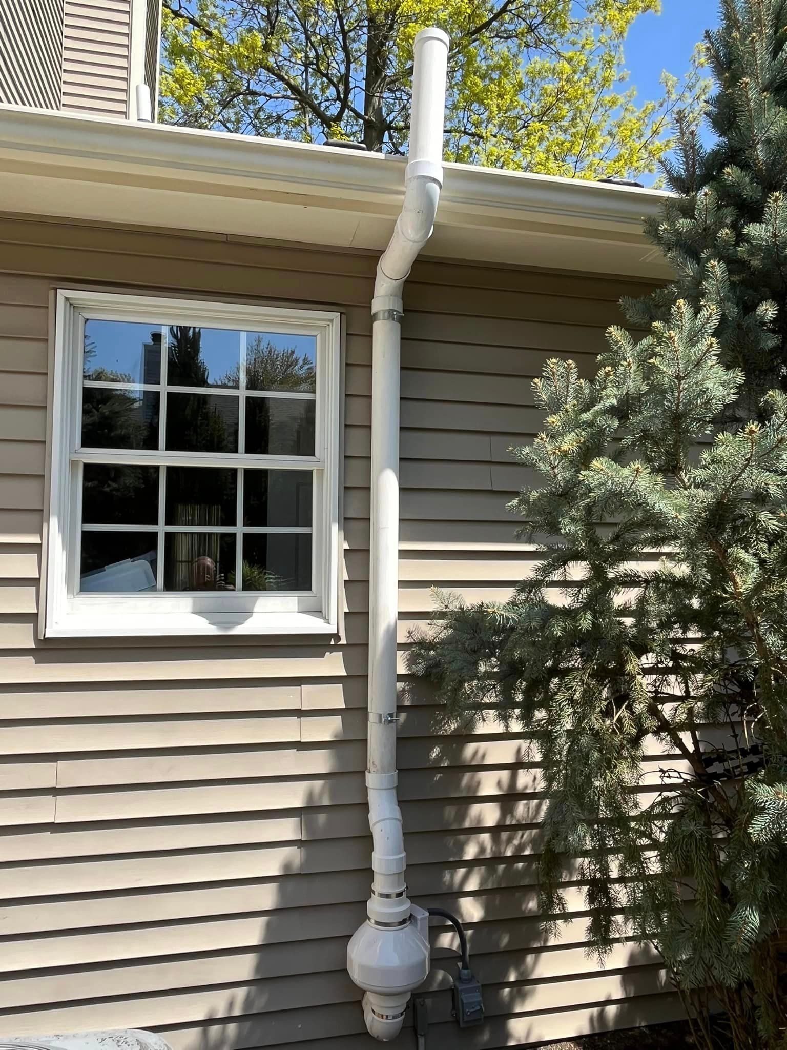 A house with a white gutter on the side of it and a window.