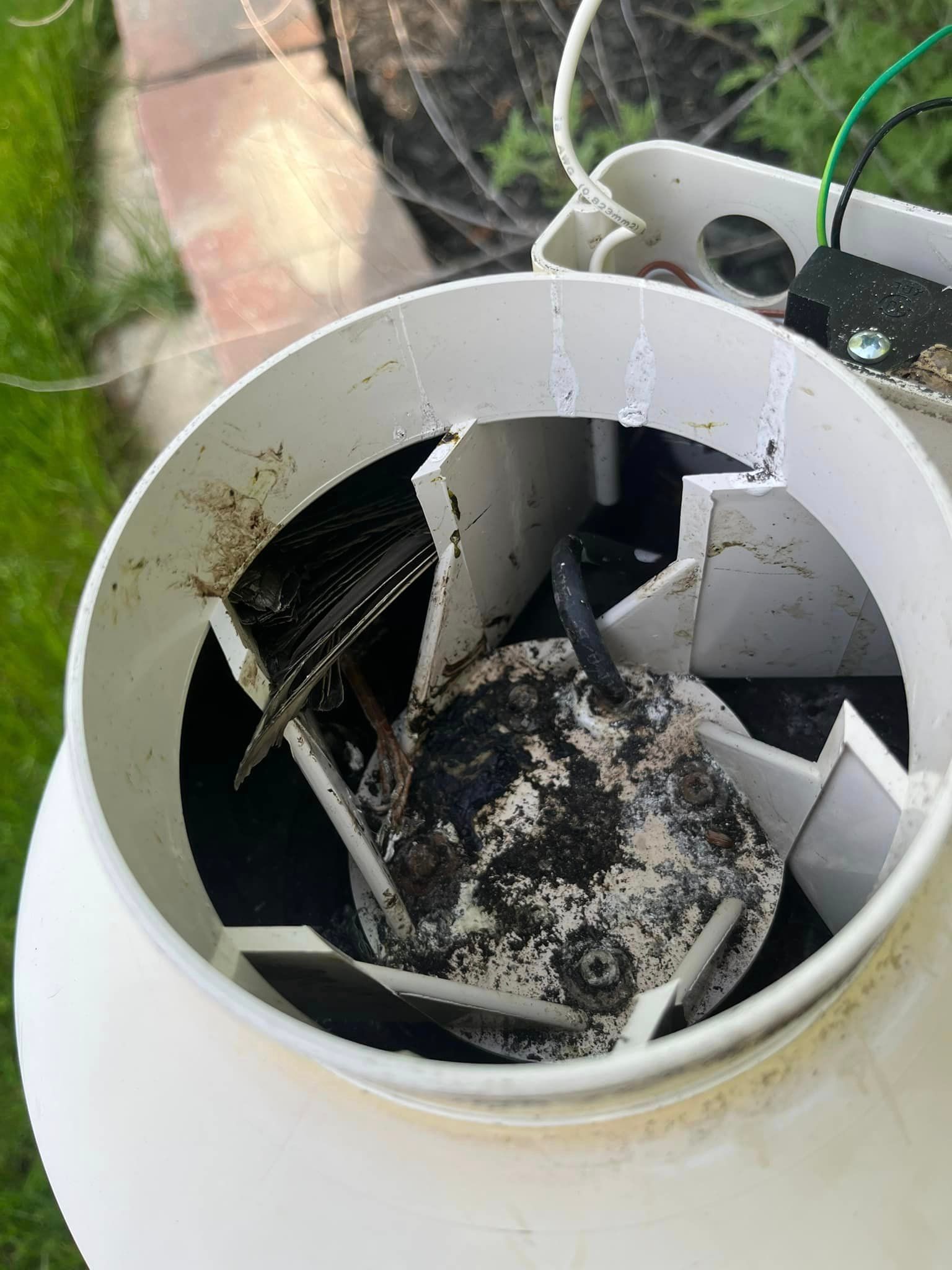 A broken fan is sitting inside of a white container.