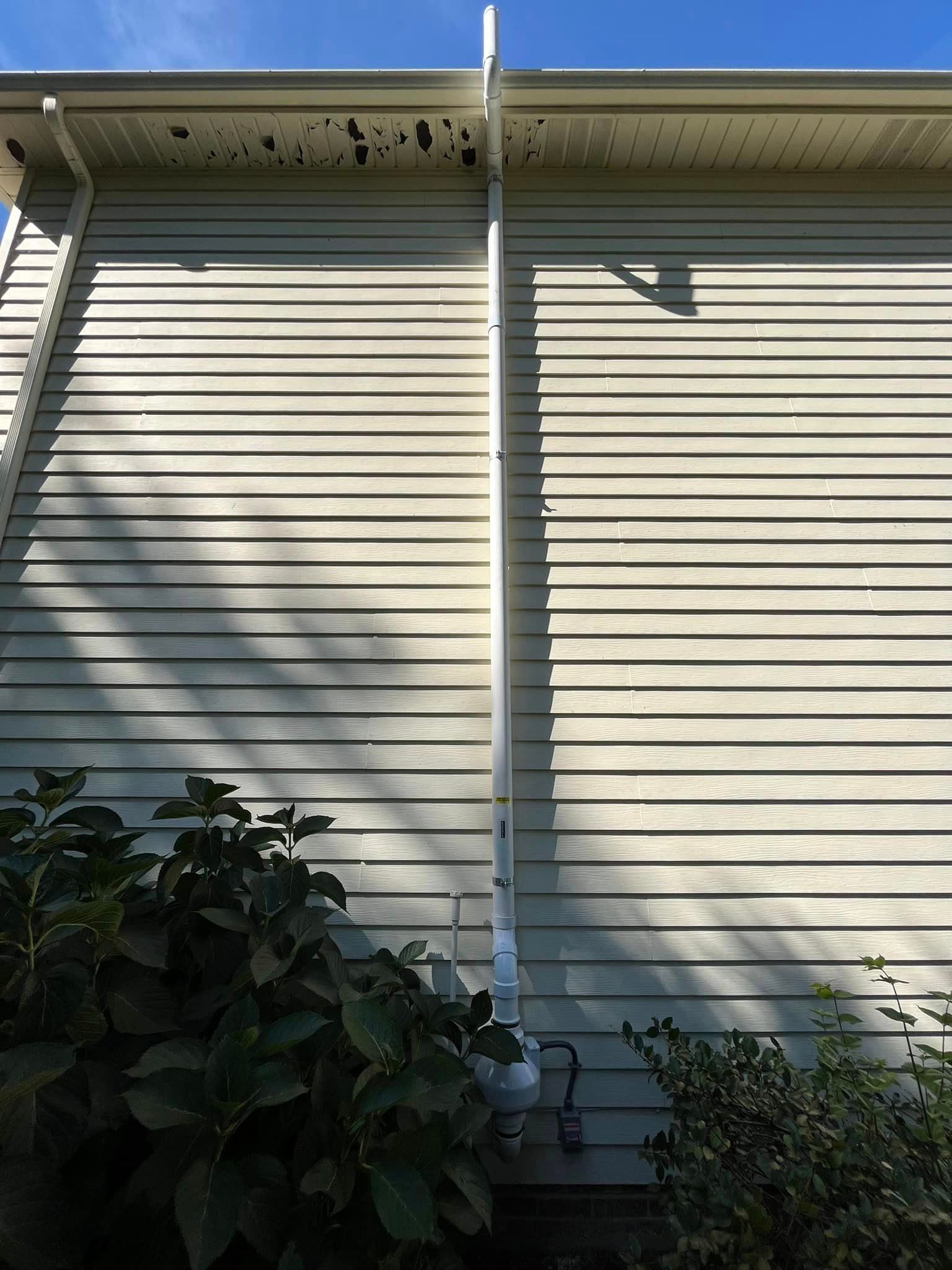A white house with a white gutter on the side of it