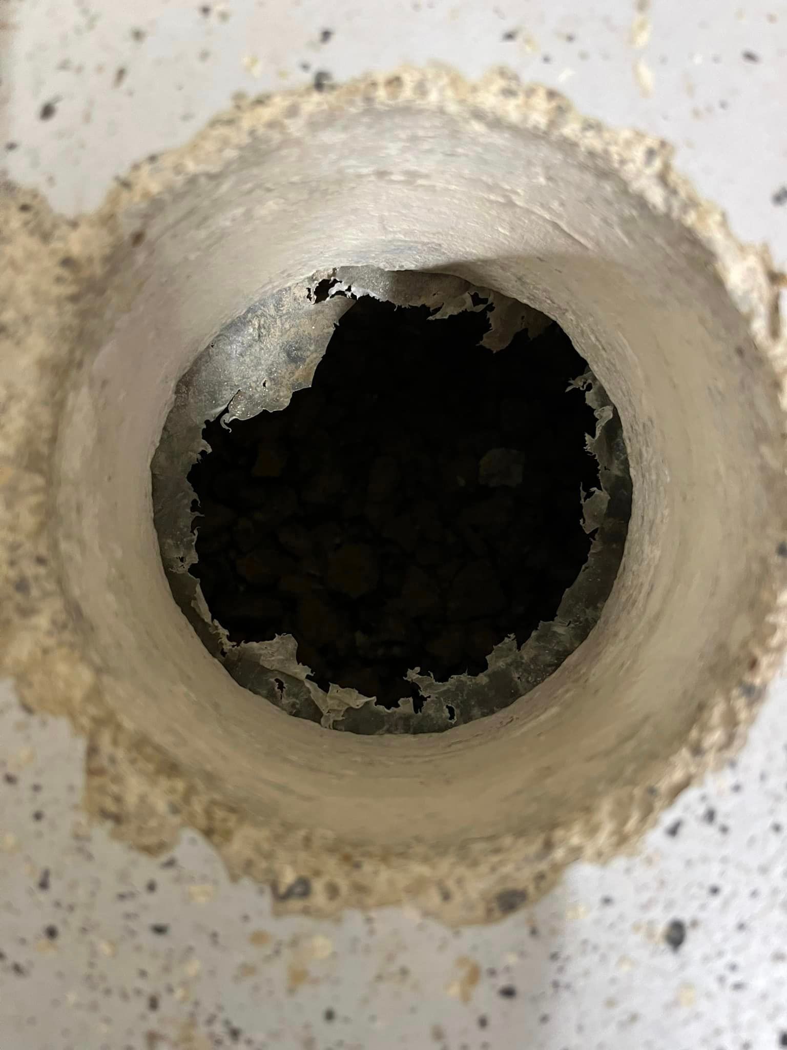 A close up of a hole in a metal pipe.