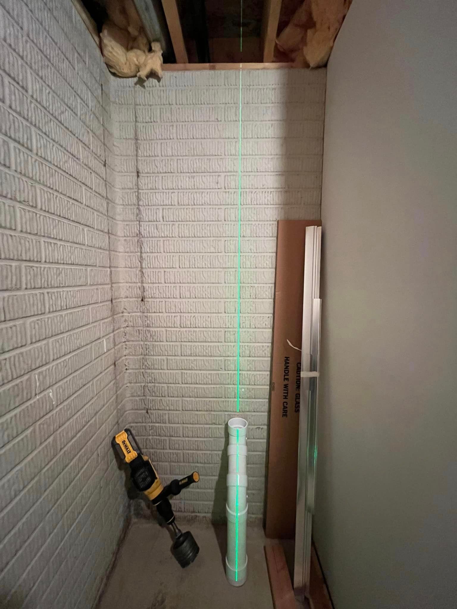 A room with a brick wall and a green laser.