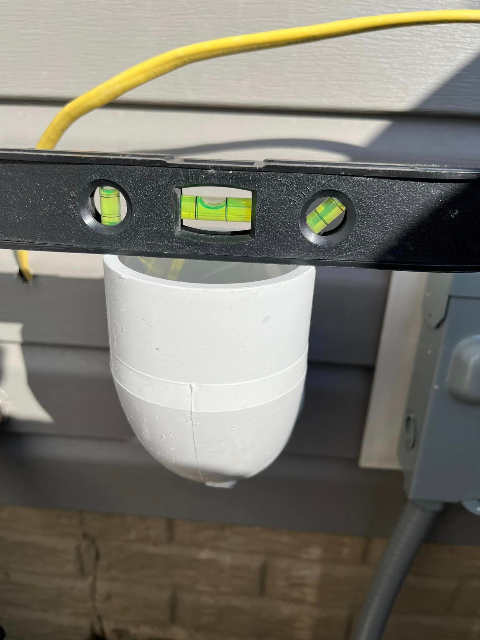 A level is being used to check the level of a pvc pipe.