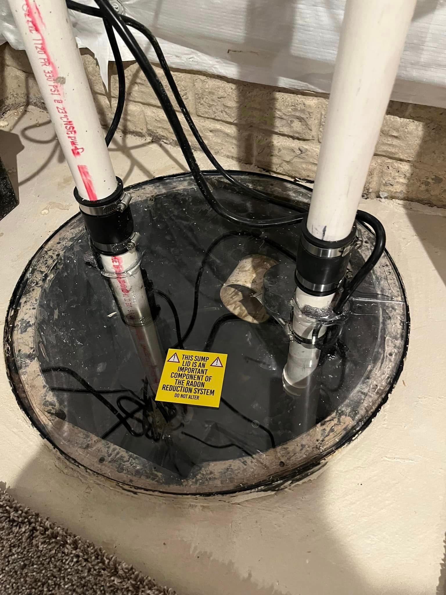 A close up of a sump pump with a yellow tag on it.
