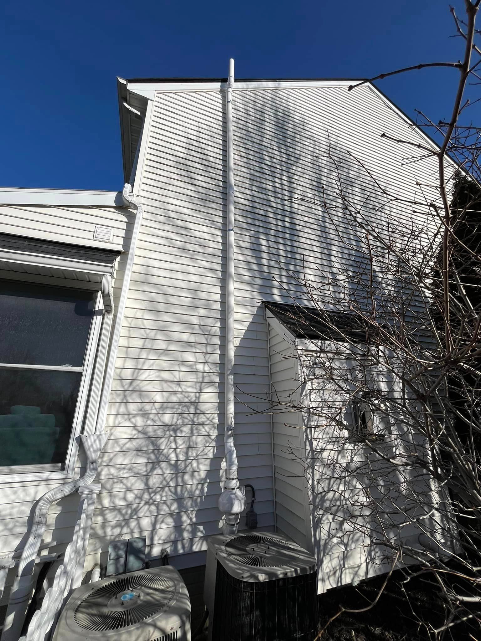 A white house with a chimney on the side of it.