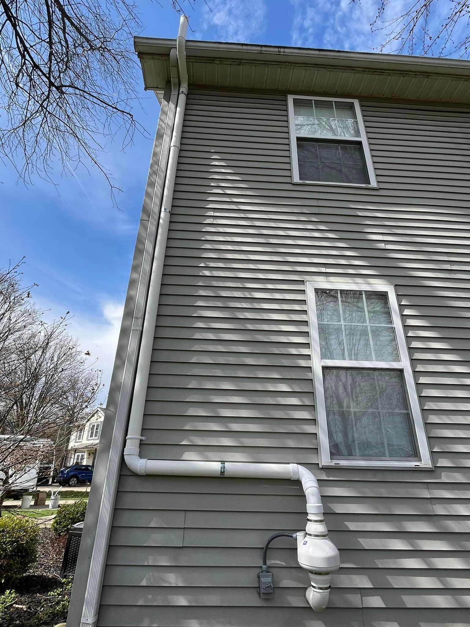 A house with a white pipe attached to the side of it.