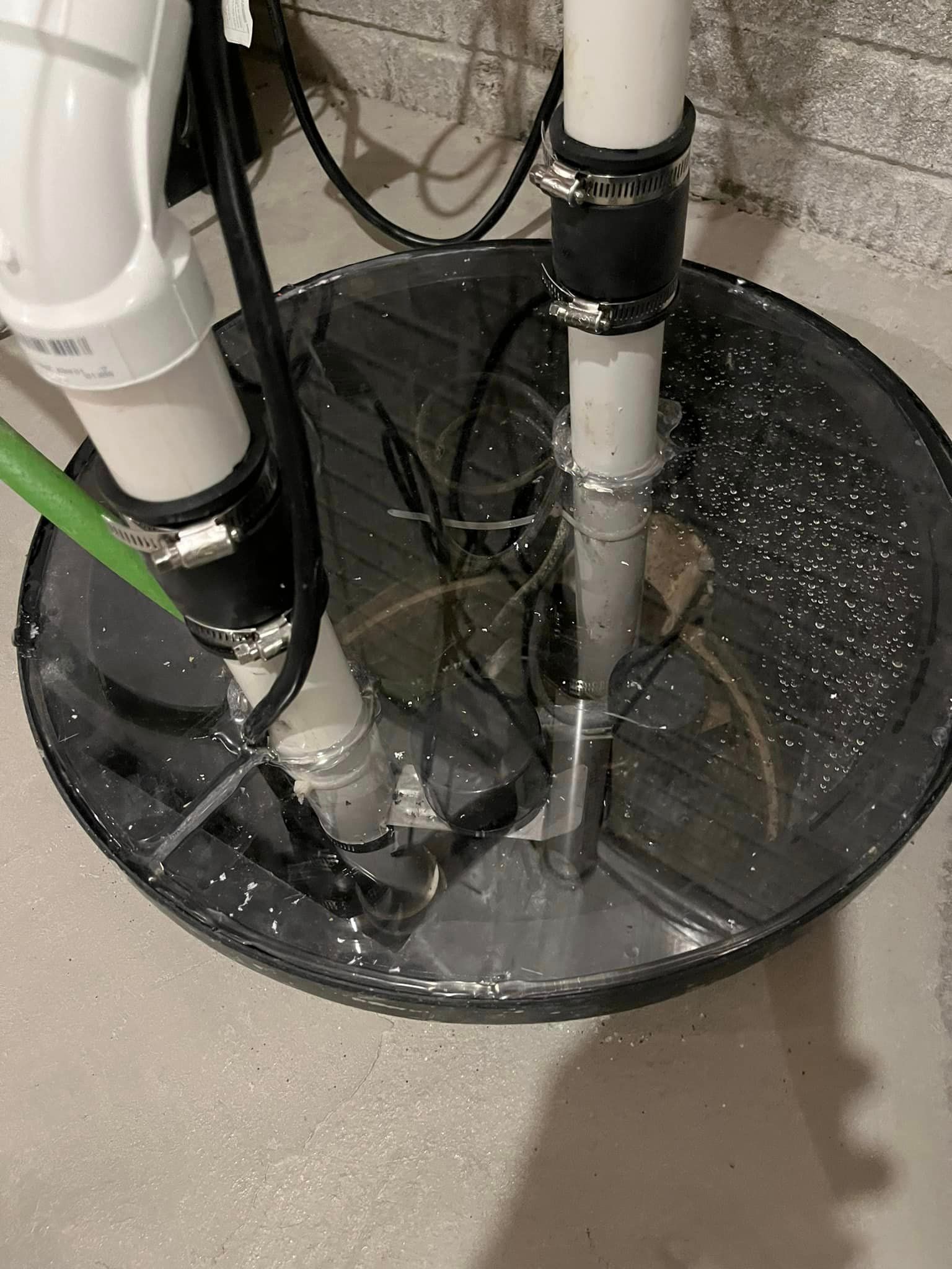 A close up of a basement drain with water coming out of it.