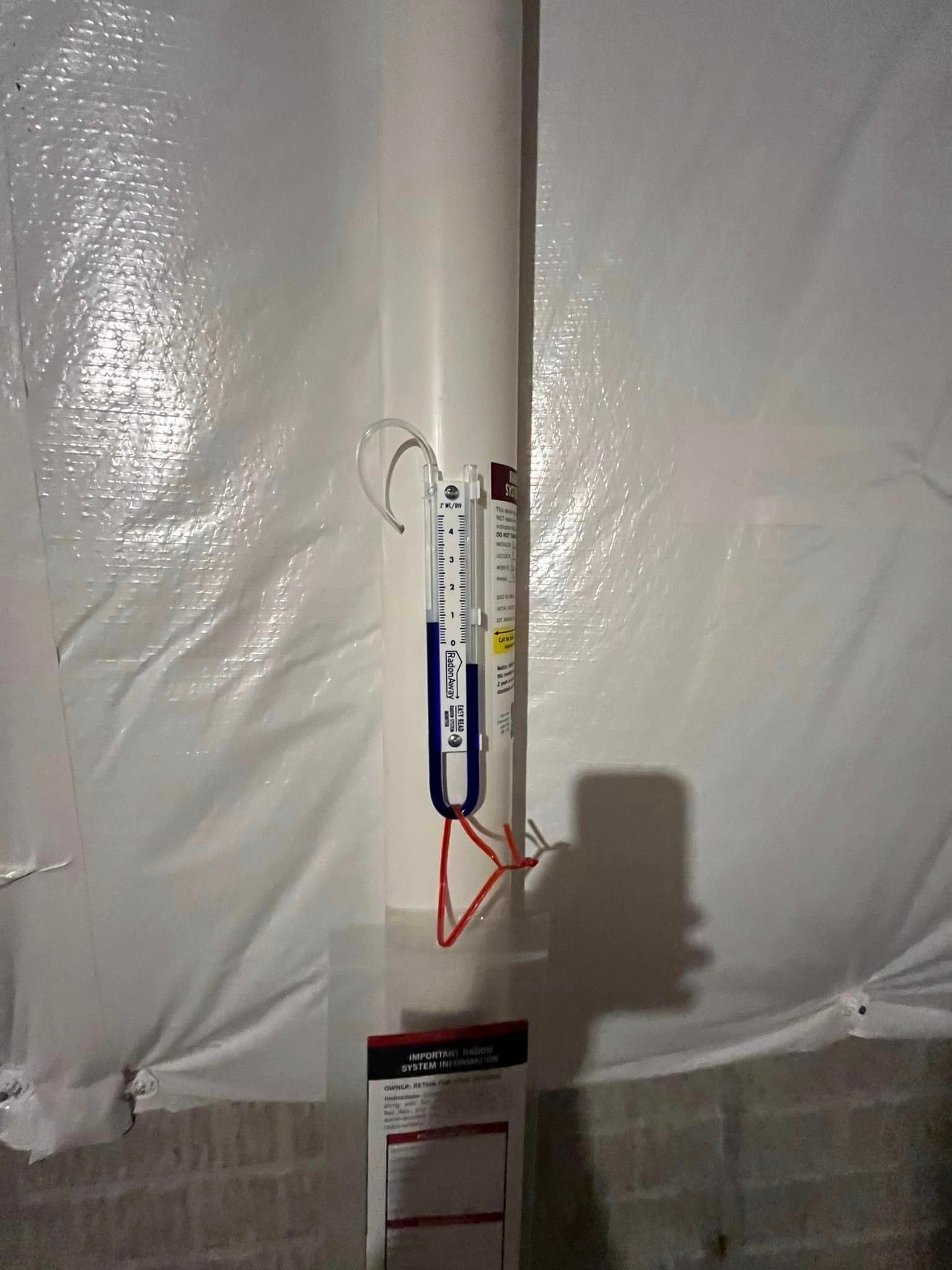A white pipe with a thermometer attached to it.