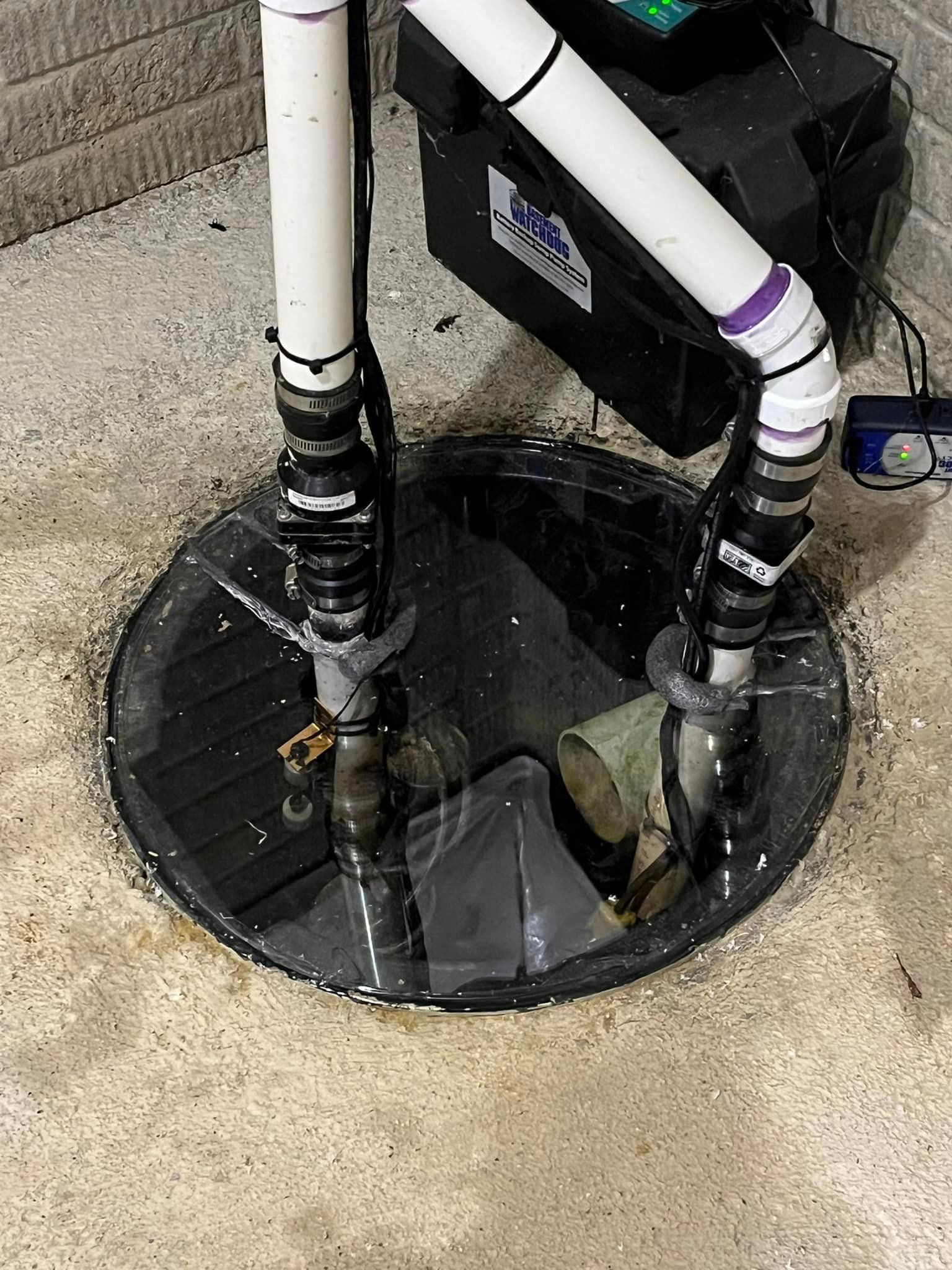 A close up of a sump pump in a basement.
