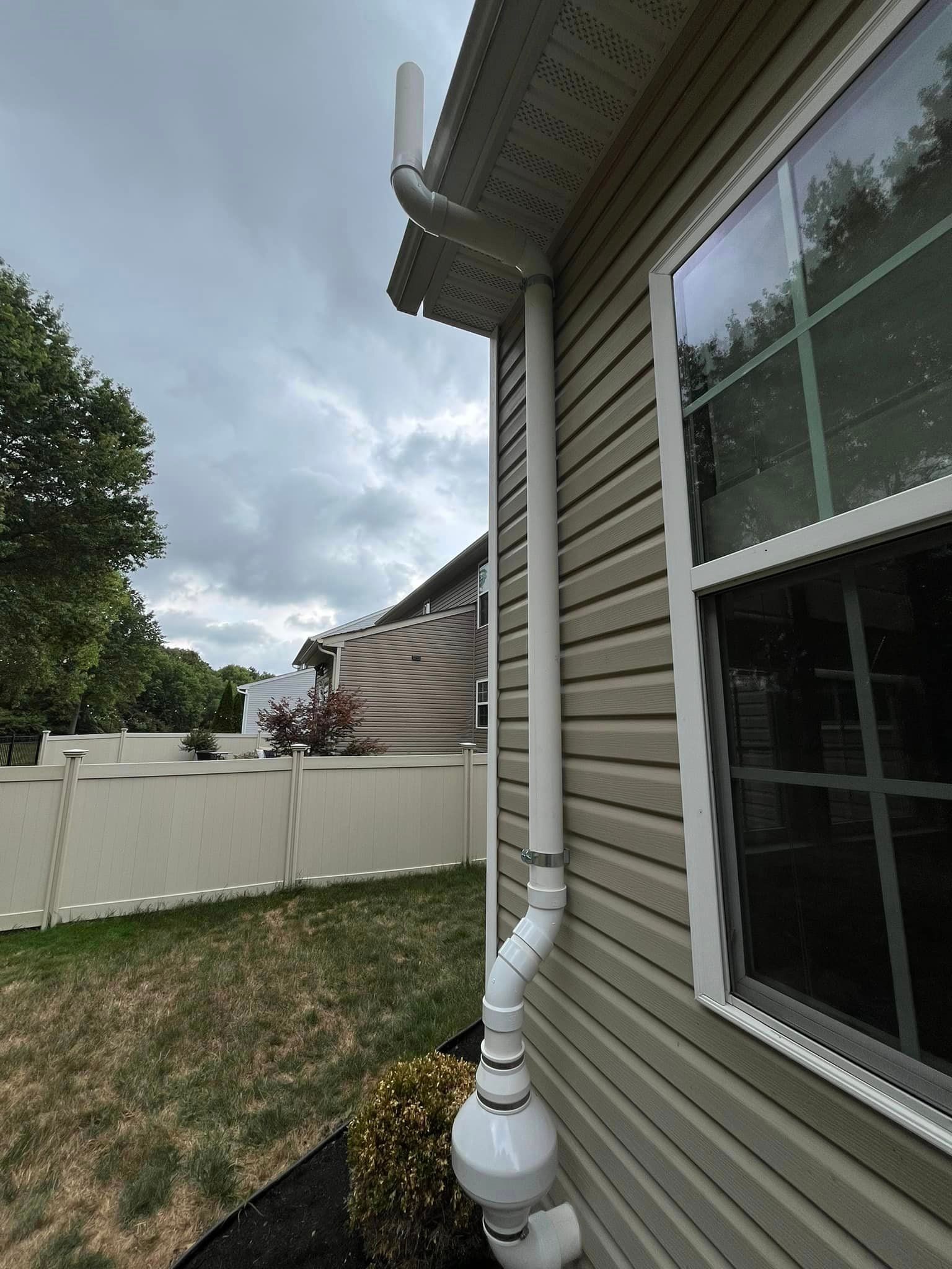 A house with a gutter on the side of it and a window.