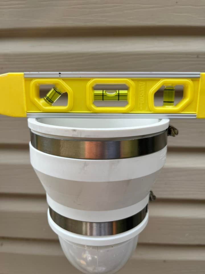 A yellow level is sitting on top of a white cup.