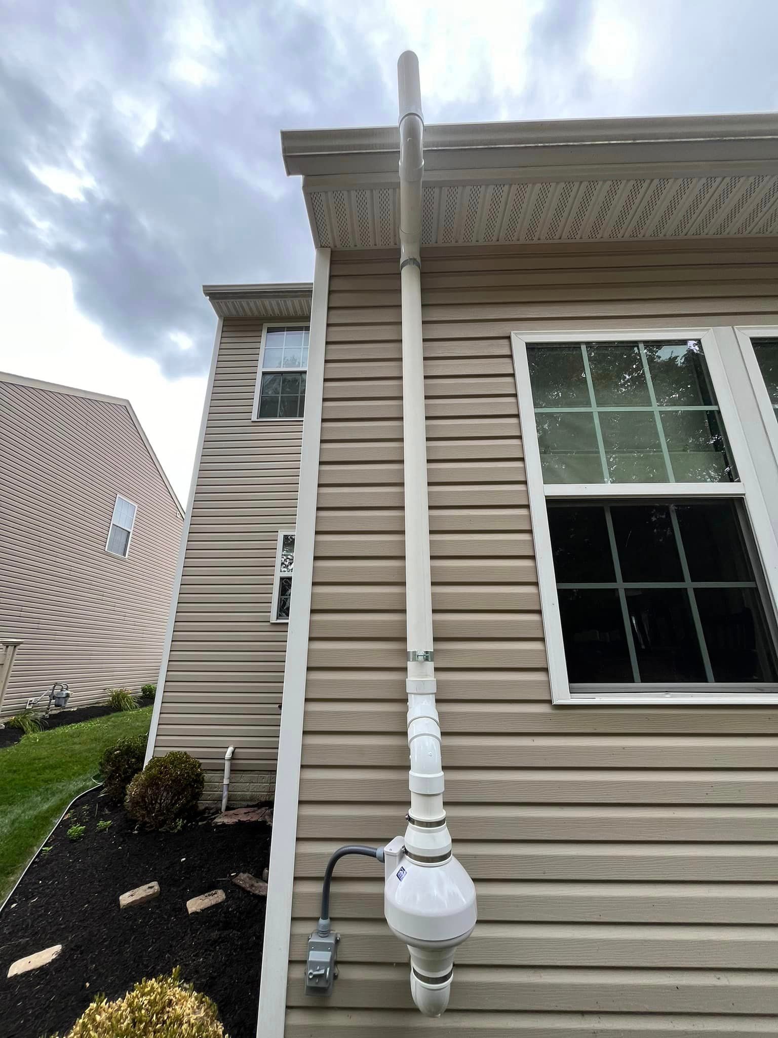 A house with a drain pipe attached to the side of it.