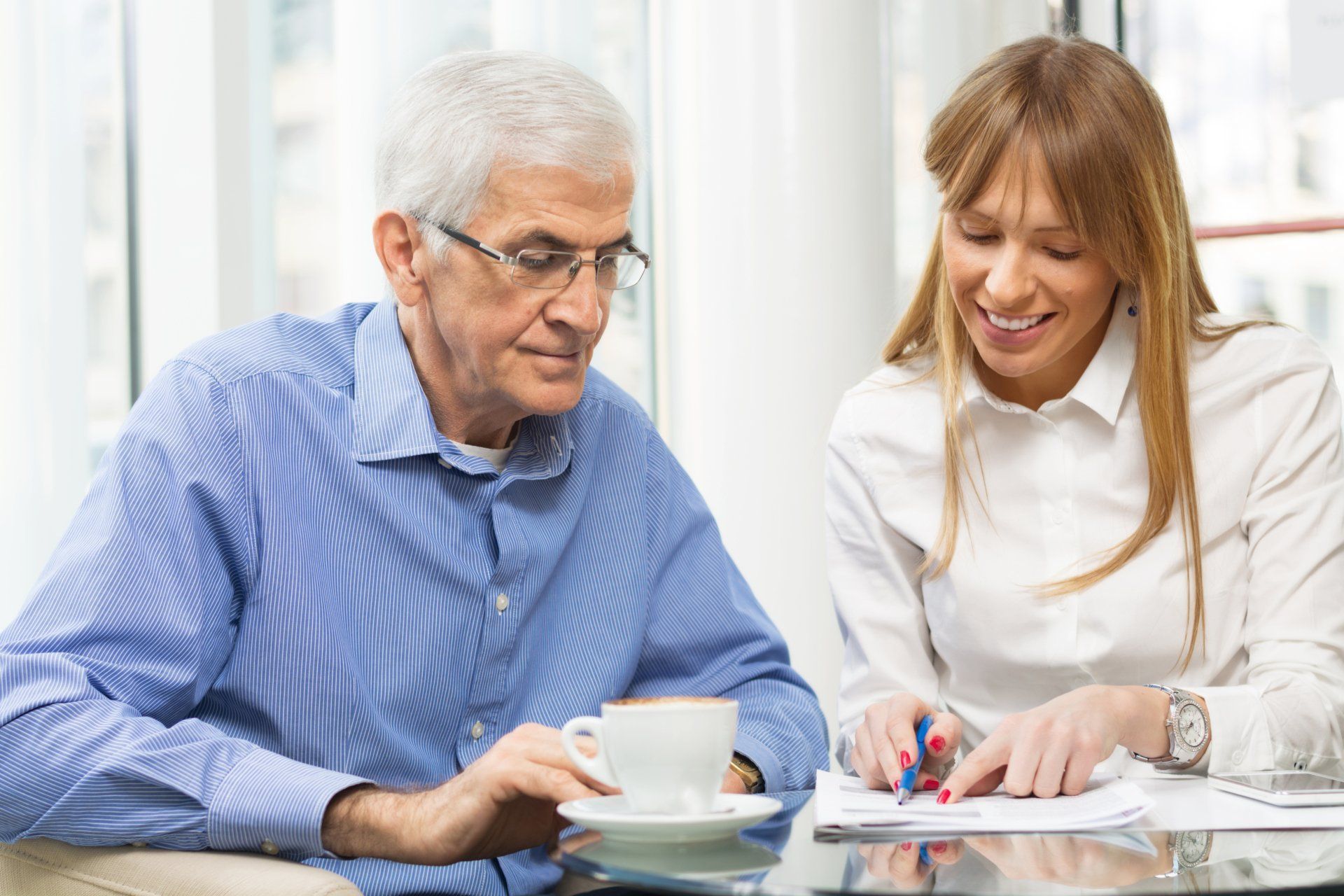 A man and a woman are sitting at a table looking at a piece of paper.